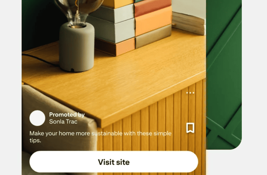 A promotional pin featuring a cabinet, lamp, and books with advice on a green home